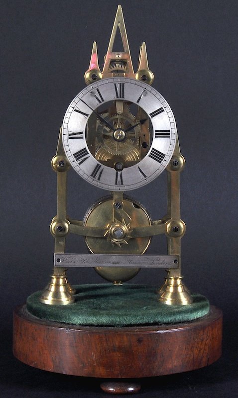 A SMALL BRASS SKELETON CLOCK in a glass dome, ÂWeek