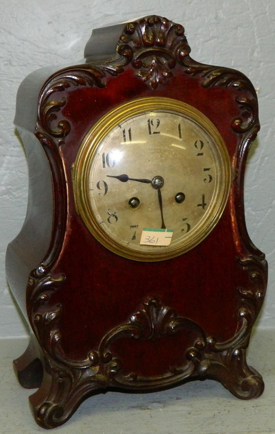 Mahogany 8 day clock with carved attachments.