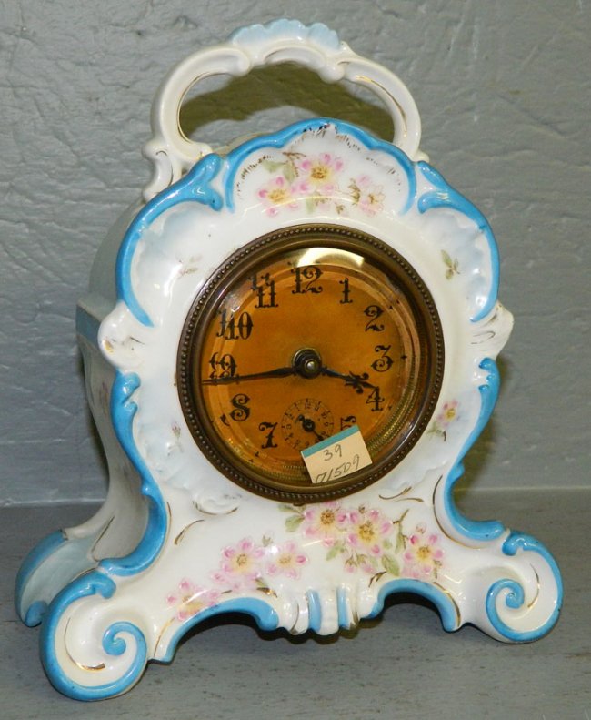 White porcelain alarm clock with floral detail.