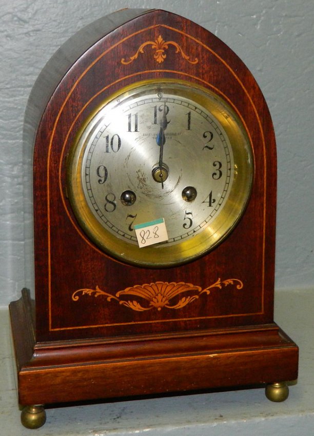 French mahogany clock w/ fleur-de-lis inlay.