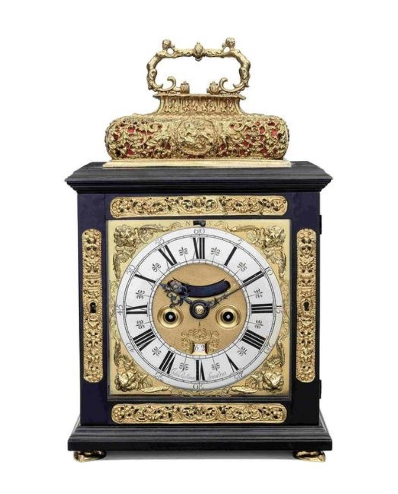 A late 17th century ebony basket topped table clock