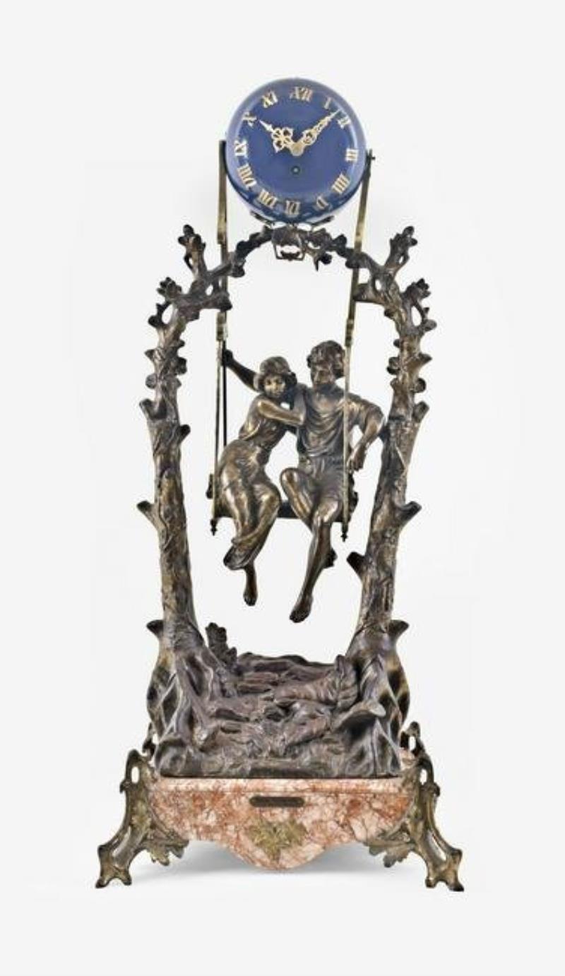 A turn of the 20th century couple on a swing figural mystery clock