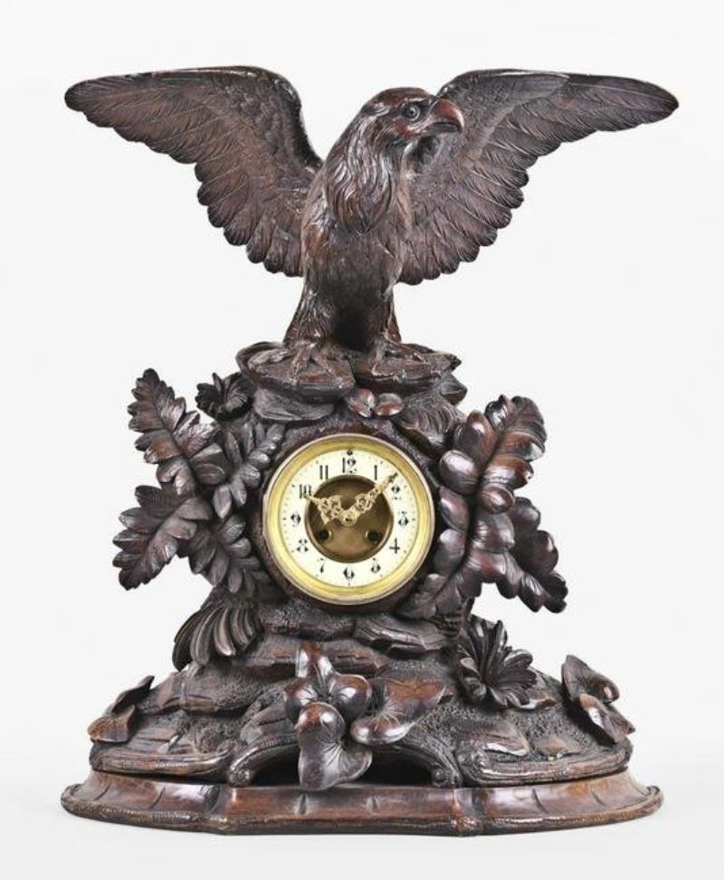 A good turn of the 20th century carved figural Black Forest clock with eagle