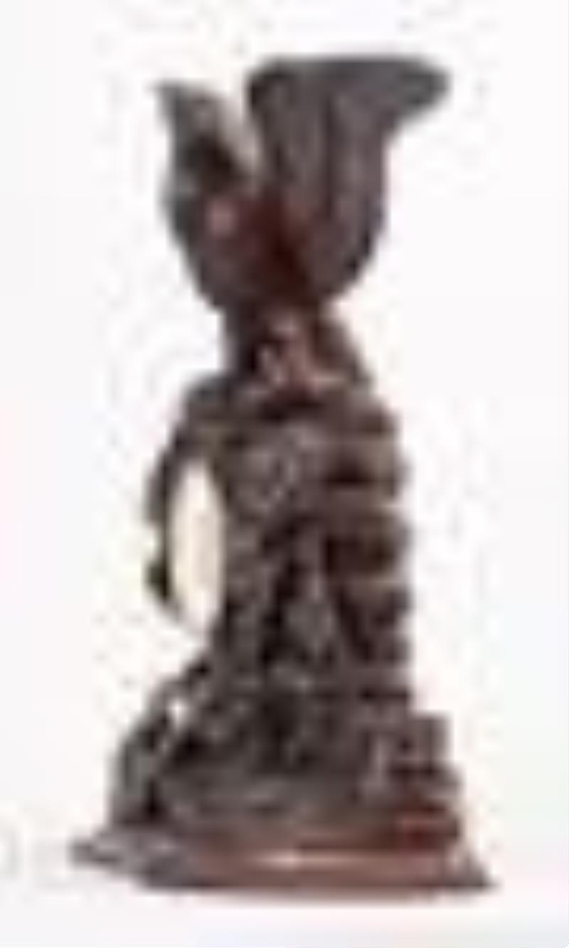 A good turn of the 20th century carved figural Black Forest clock with eagle